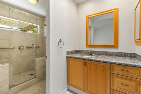 a bathroom with a granite countertop sink and a mirror