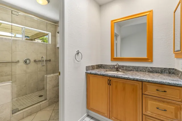 a bathroom with a granite countertop sink and a mirror