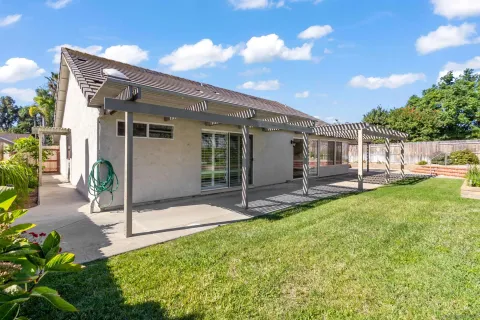 a view of a house with backyard and sitting area