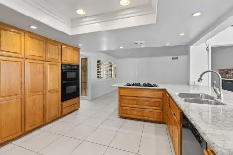 a kitchen with stainless steel appliances granite countertop a sink and a refrigerator