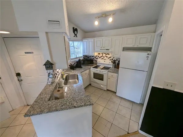 a kitchen with sink stove and cabinets