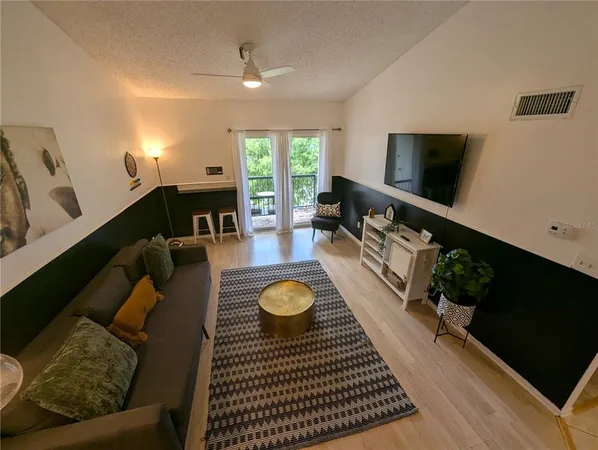 a living room with furniture a flat screen tv and a large window