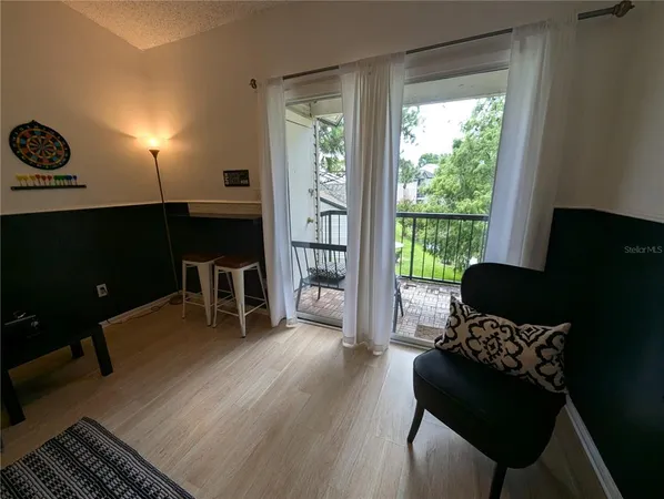 a living room with furniture lamp and a large window
