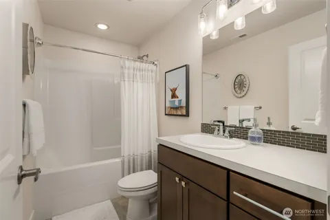 a bathroom with a sink a toilet a mirror and shower