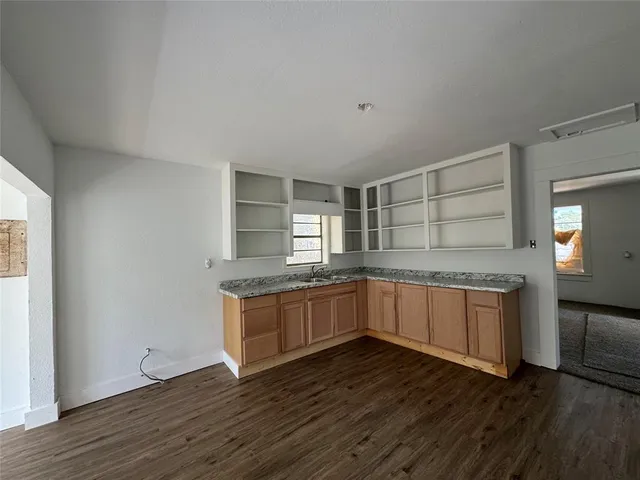 a kitchen with stainless steel appliances granite countertop a stove and a wooden floors