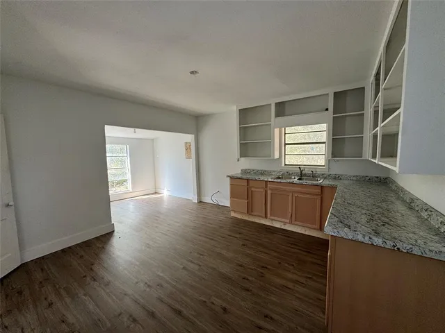 a kitchen with granite countertop a stove and a wooden floors