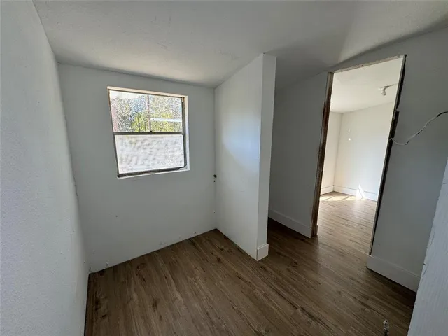 an empty room with wooden floor and a window