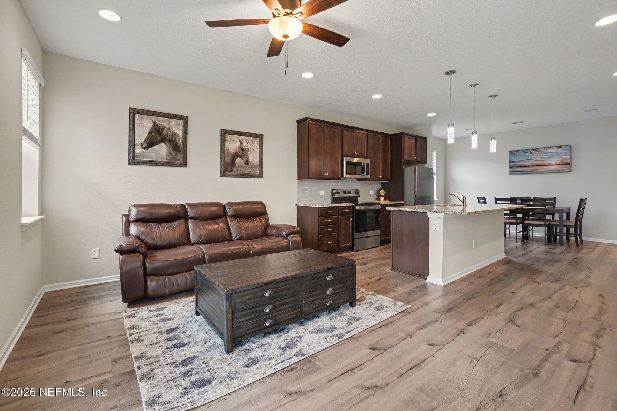 4630 Pine Ridge Parkway Middleburg, FL 32068 - Photo 4 of 35 a living room with stainless steel appliances furniture and a kitchen view