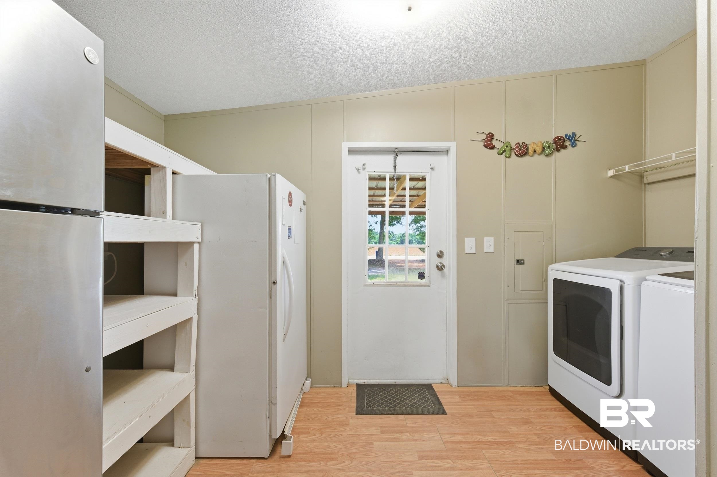 926 Tumbling Lane Atmore, AL 36502 - Photo 23 of 56 Utility space featuring wood-finish flooring and light-toned paneled walls