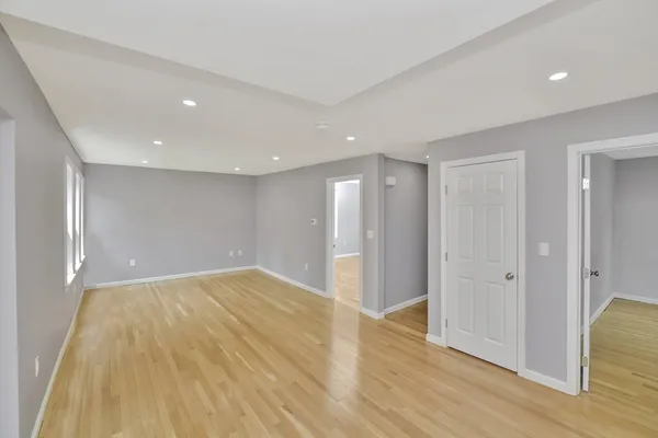 a view of an empty room with wooden floor