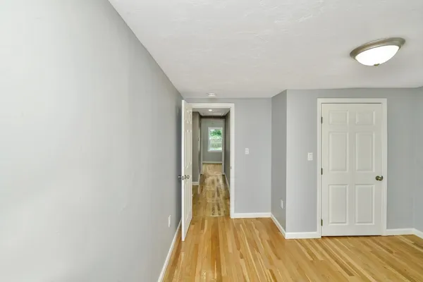 a view of a room with wooden floor and door