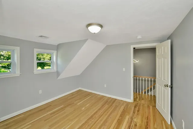 a view of a room with wooden floor and a window