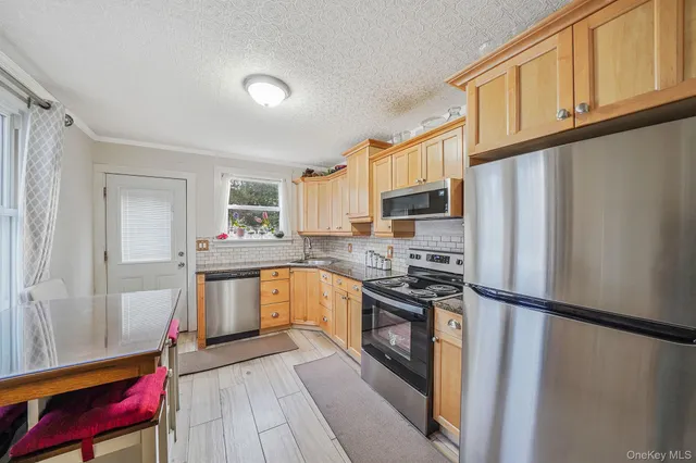 a kitchen with granite countertop a refrigerator stove and sink