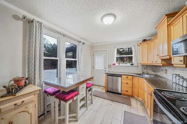 a kitchen with granite countertop a stove and white cabinets