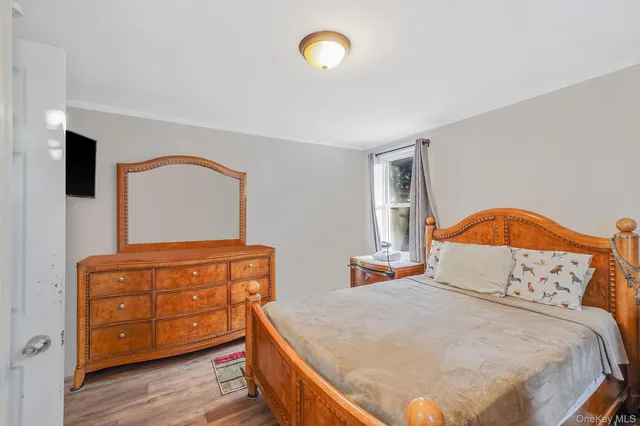 a bedroom with bed and wooden floor