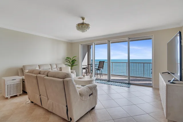 a living room with furniture and a floor to ceiling window