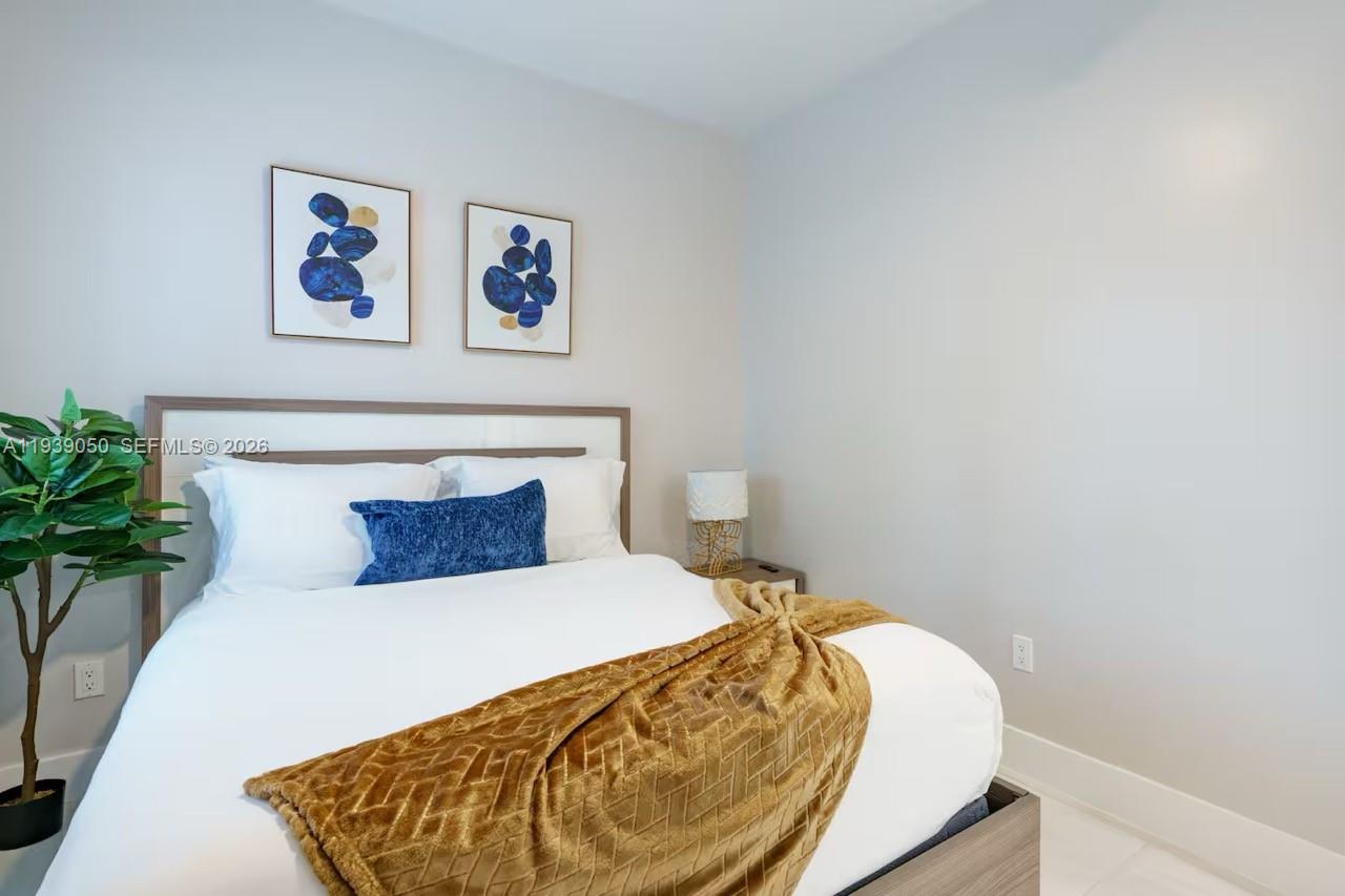 1721 Southwest 11th Terrace Miami, FL 33135 - Photo 25 of 60 a bed sitting in a bedroom and painting on the wall