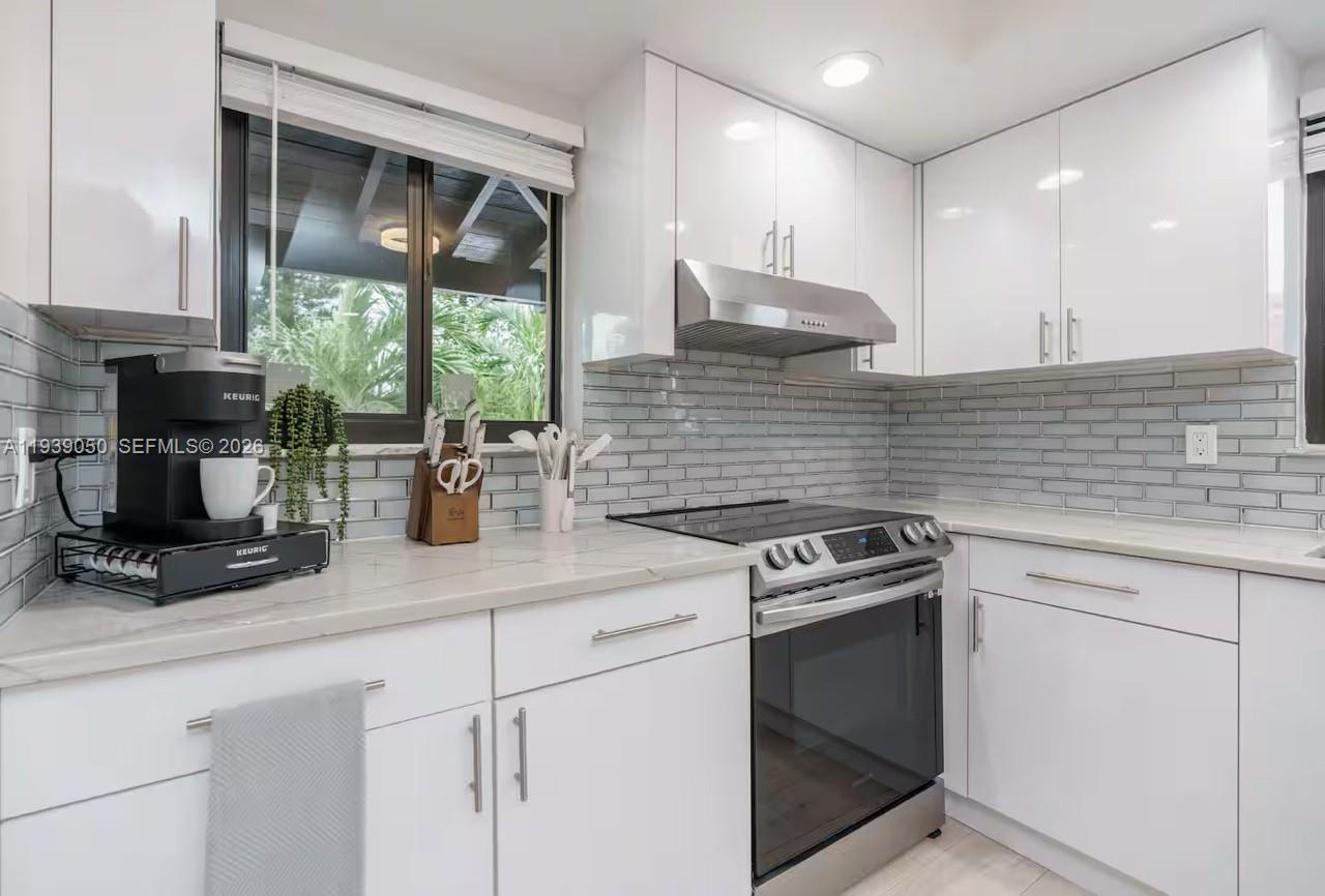 1721 Southwest 11th Terrace Miami, FL 33135 - Photo 33 of 60 a kitchen with a stove a sink and a microwave
