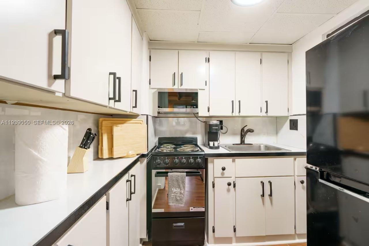 1721 Southwest 11th Terrace Miami, FL 33135 - Photo 54 of 60 a kitchen with stainless steel appliances granite countertop a stove a sink and a microwave