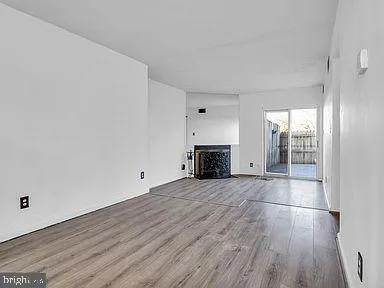 an empty room with wooden floor and fireplace