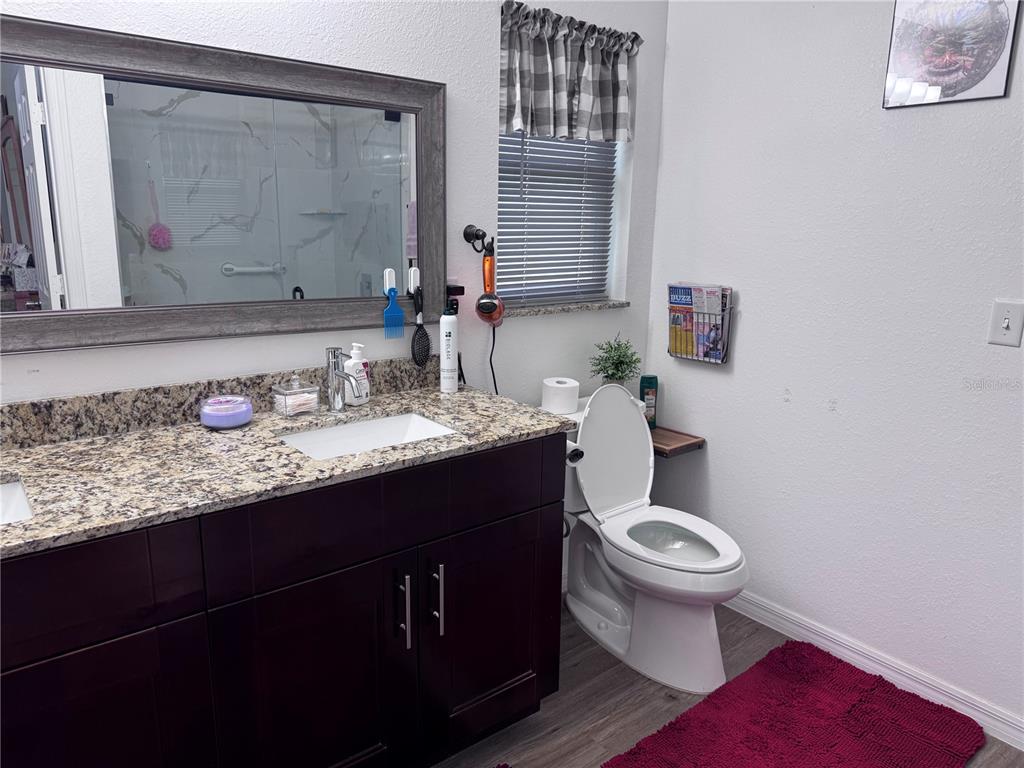 1855 North Berkley Road Avon Park, FL 33825 - Photo 16 of 28 a bathroom with a granite countertop toilet sink and mirror