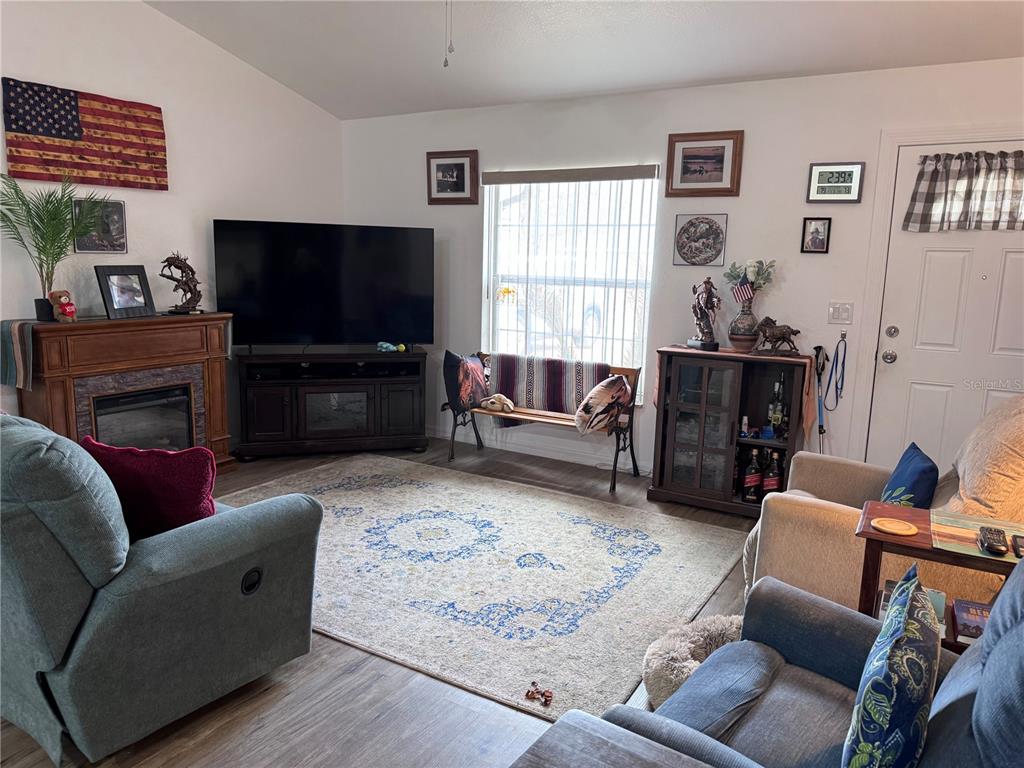 1855 North Berkley Road Avon Park, FL 33825 - Photo 6 of 28 a living room with furniture a flat screen tv and a fireplace