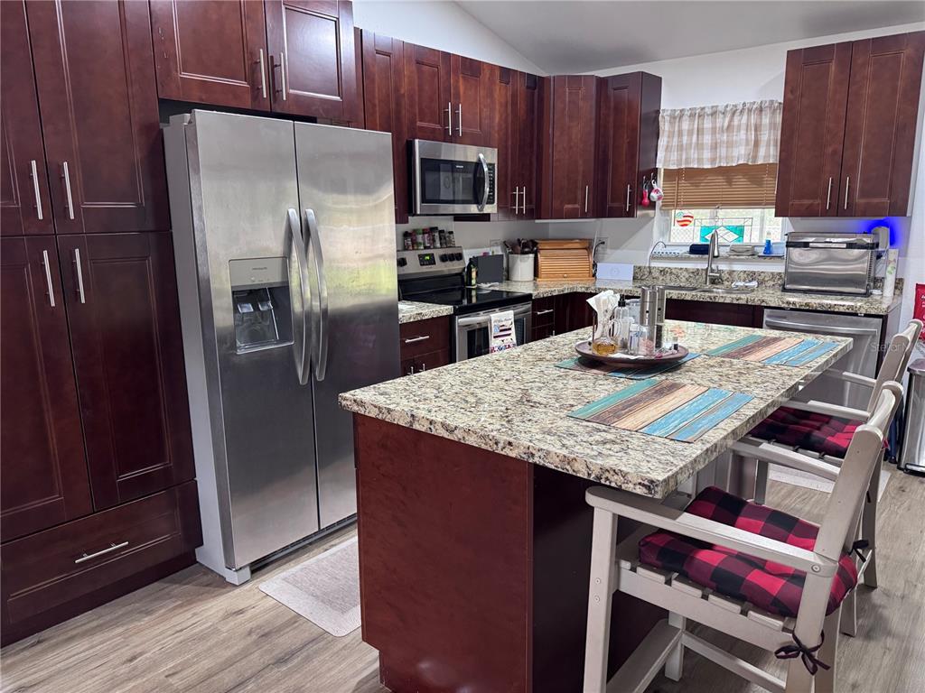 1855 North Berkley Road Avon Park, FL 33825 - Photo 7 of 28 a kitchen with granite countertop a refrigerator stove and microwave