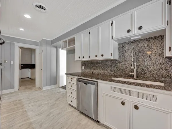 a kitchen with white cabinets and white appliances