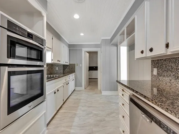 a kitchen with stainless steel appliances granite countertop a stove and a microwave