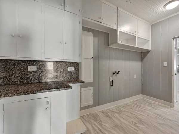 a kitchen with granite countertop white cabinets and stainless steel appliances