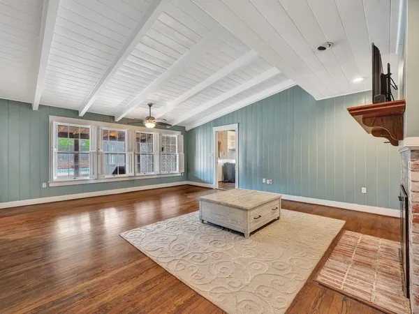a living room with hardwood floor and large window