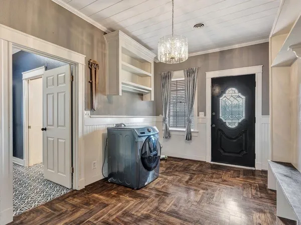 a view of a hallway with wooden floor and chandelier