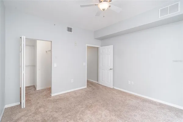 a view of an empty room with a chandelier fan