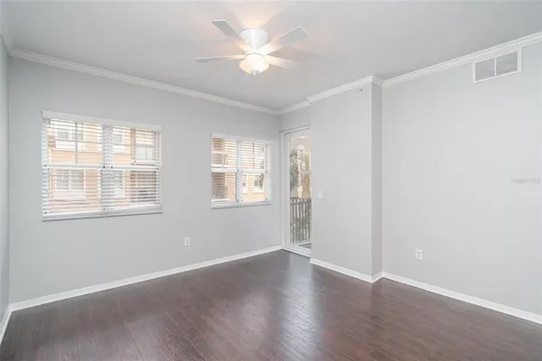 an empty room with wooden floor and windows