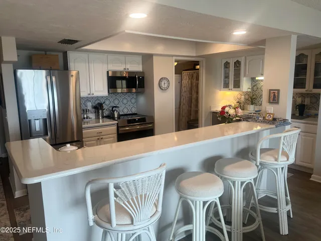 a kitchen with a refrigerator and a stove top oven