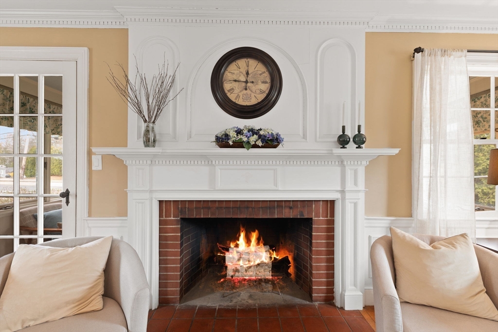 6 Tower Avenue Needham, MA 02494 - Photo 21 of 43 a living room with a fireplace a flat screen tv and a large window