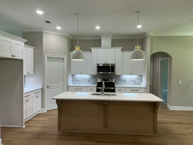 a view of kitchen with stainless steel appliances refrigerator stove microwave and cabinets
