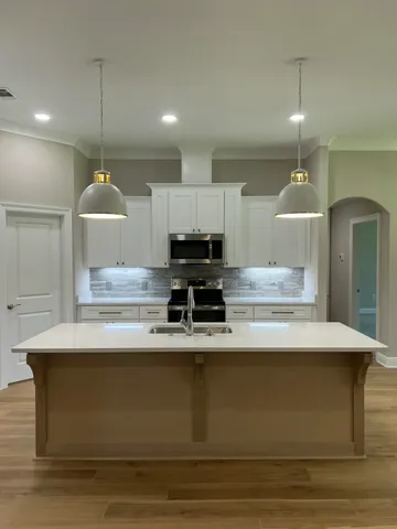 a kitchen with a sink a stove and cabinets