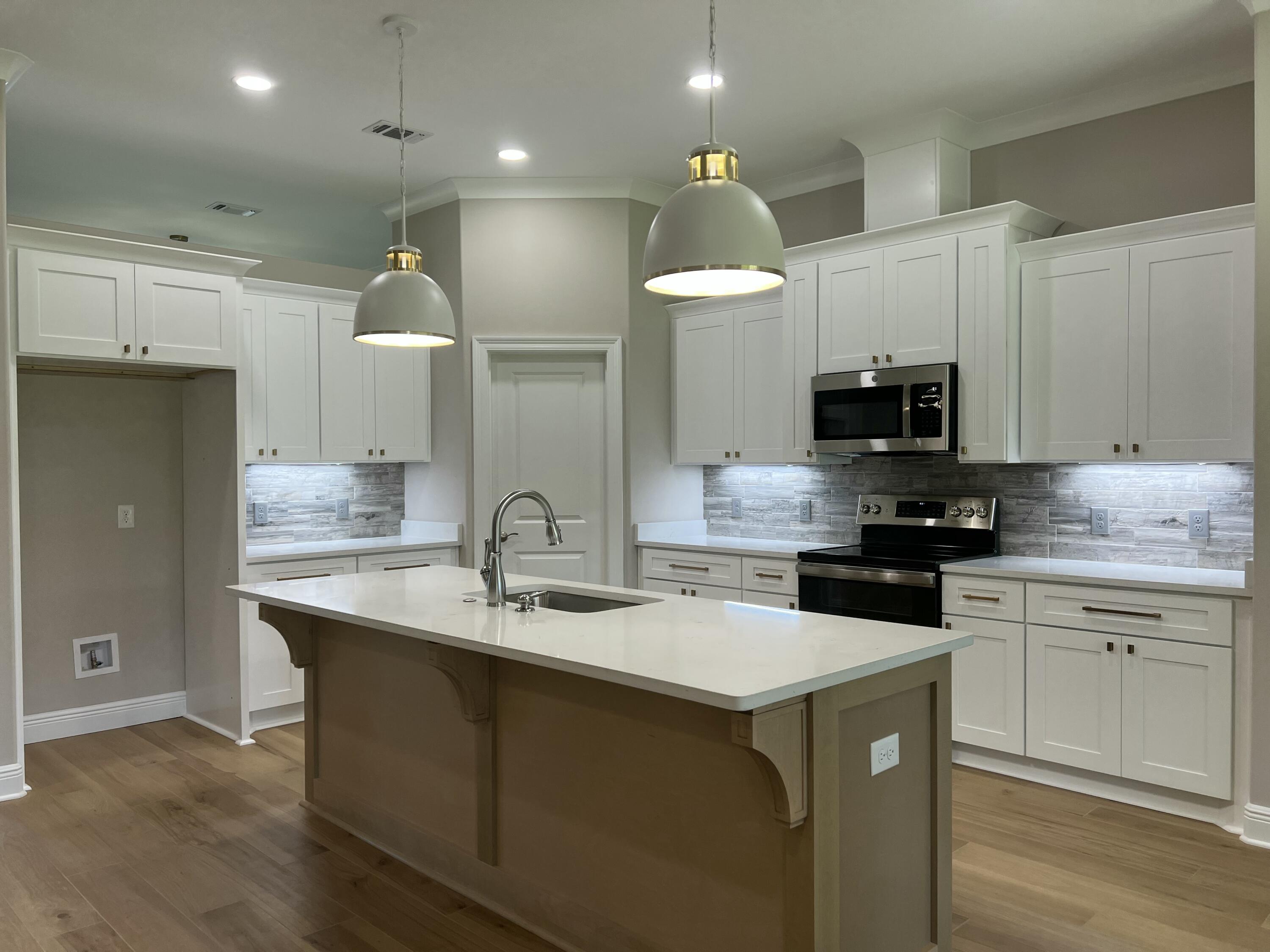 2038 Colby Court Navarre, FL 32566 - Photo 7 of 51 a kitchen with a sink a stove and cabinets