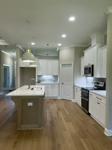 a large kitchen with kitchen island a sink stainless steel appliances and cabinets