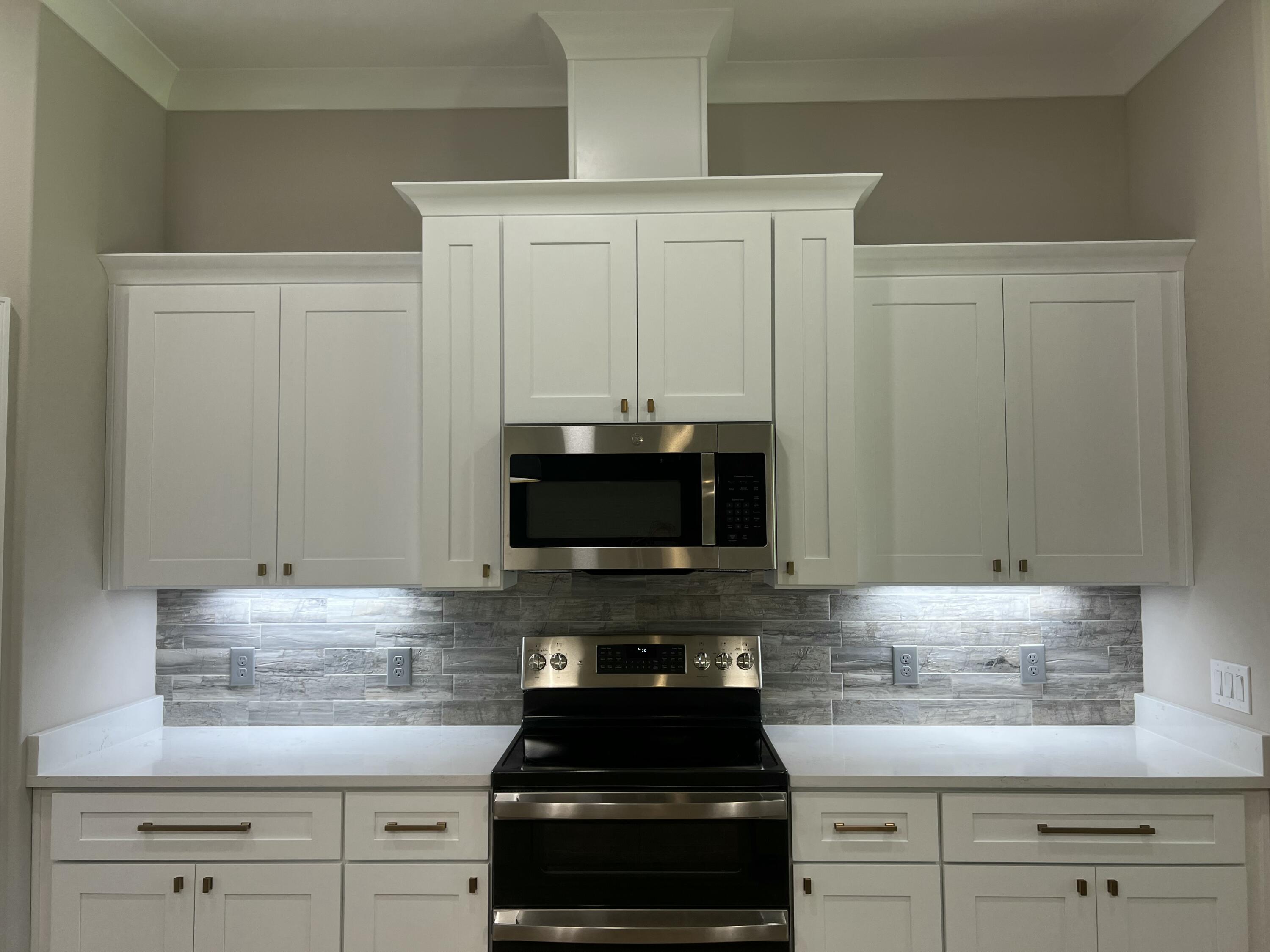 2038 Colby Court Navarre, FL 32566 - Photo 10 of 51 a kitchen with granite countertop white cabinets and black appliances