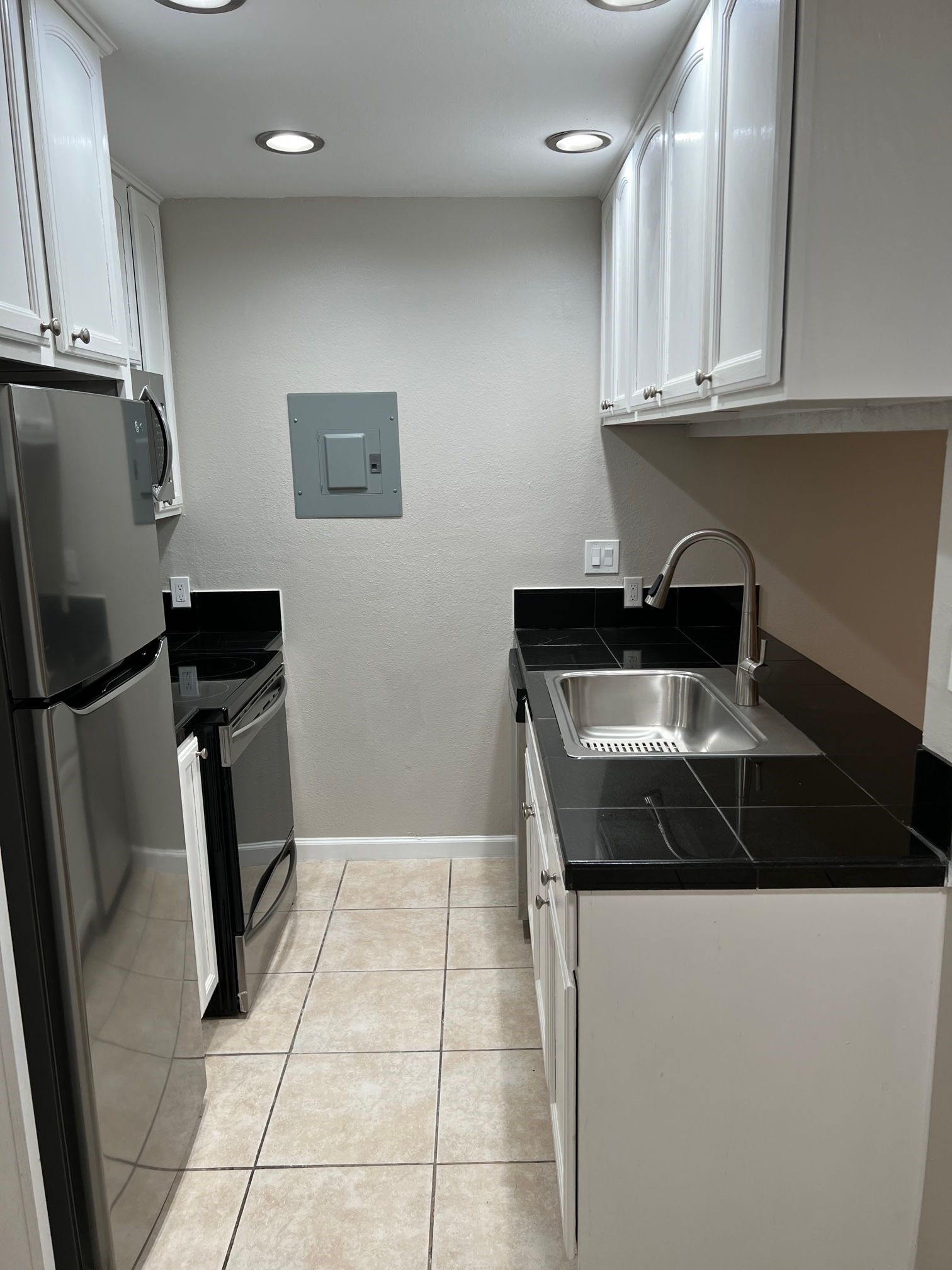 2413 Leon Street, Unit 103 Austin, TX 78705 - Photo 11 of 15 a kitchen with granite countertop a refrigerator and a sink