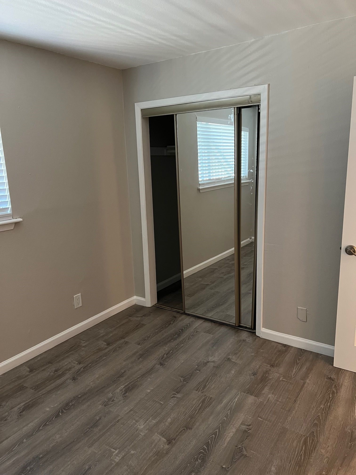 2413 Leon Street, Unit 103 Austin, TX 78705 - Photo 5 of 15 an empty room with wooden floor and windows
