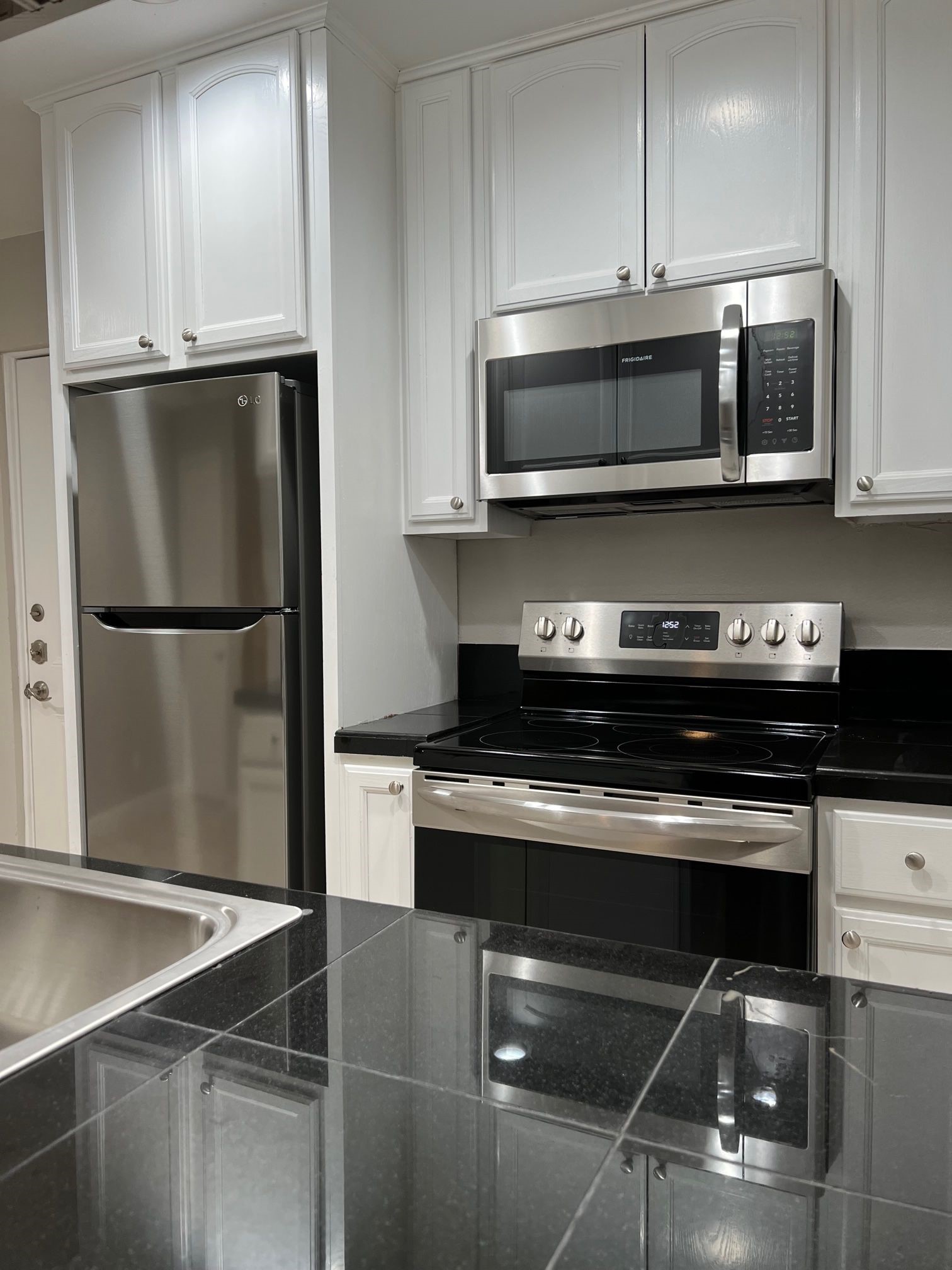 2413 Leon Street, Unit 103 Austin, TX 78705 - Photo 10 of 15 a kitchen with stainless steel appliances a refrigerator stove and microwave