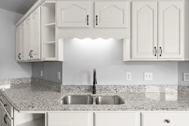 a kitchen with granite countertop white cabinets and a counter top space