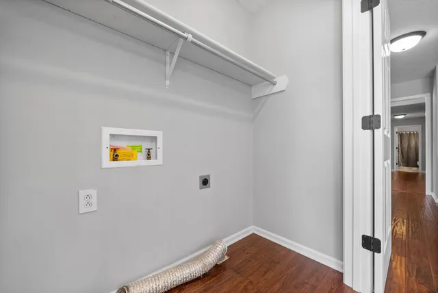 a view of a small space with wooden floor and hallway