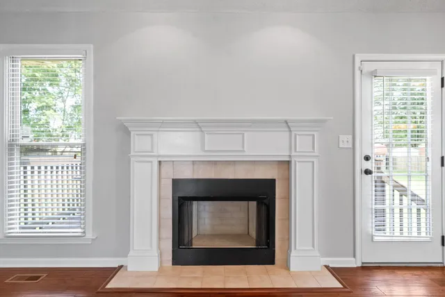 a living room with a fireplace and wooden floor