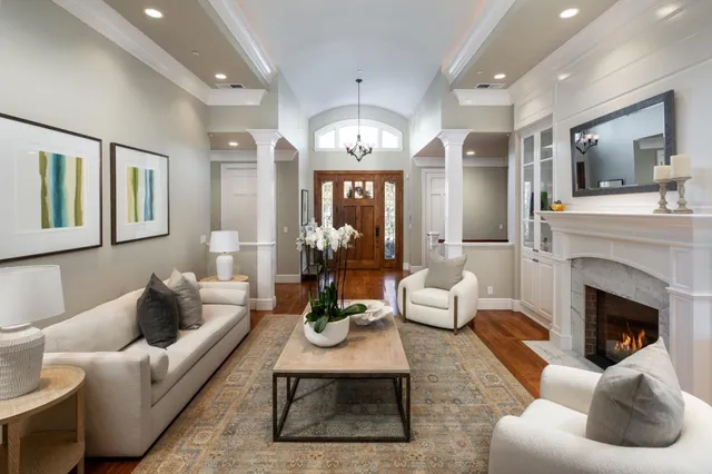 a living room with furniture fireplace and chandelier