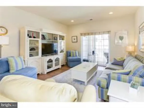 a living room with furniture a flat screen tv and a flat screen tv