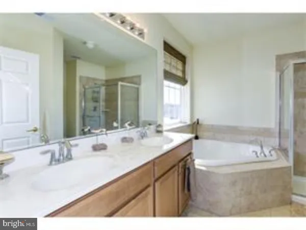 a bathroom with a tub sink and mirror